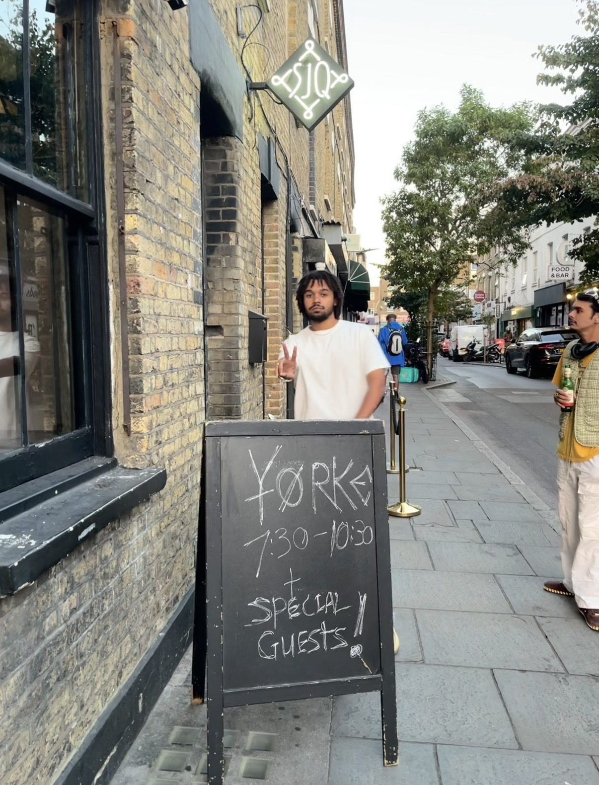 Yorke outside Servant Jazz Quarters beside an A-board reading Yorke, 7:30 to 10:30, plus special guests